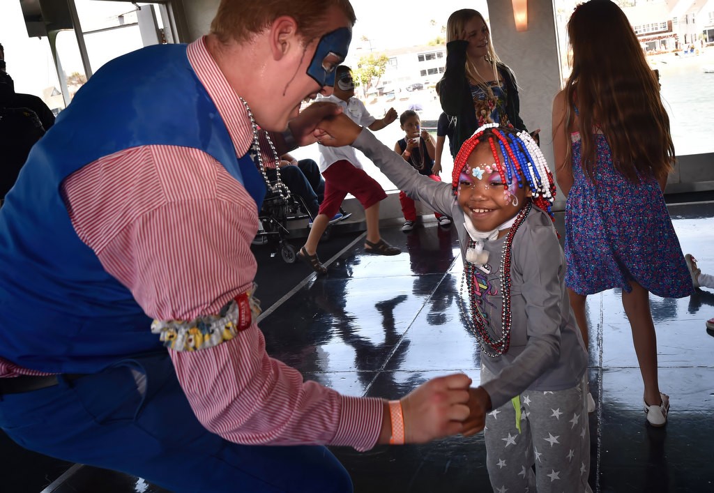 Max Werderman, an entertainment manager from Farrell's Ice Cream, dances with 11-year-old Jada Meakins during a 4th of July Newport Harbor Cruise. Photo by Steven Georges/Behind the Badge OC