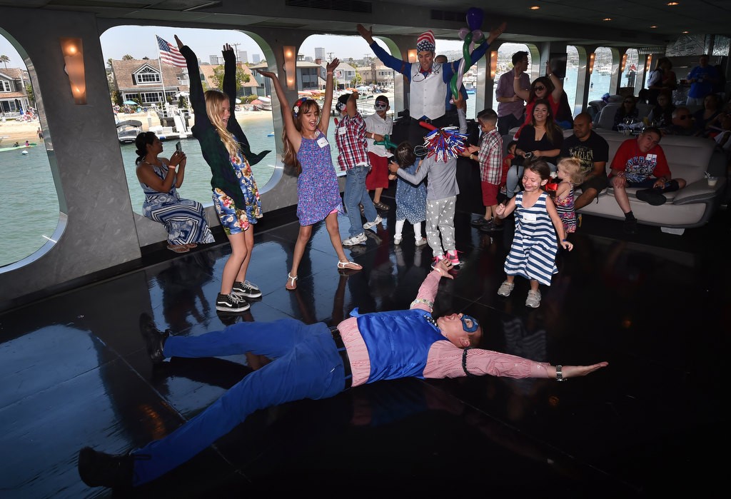 Entertainment manager from Farrell's Ice Cream Jake Koeppl and Max Werderman, on floor, dance with Make-a-Wish kids on board the Electra Cruises boat Eternity during a 4th of July Newport Harbor Cruise. Photo by Steven Georges/Behind the Badge OC