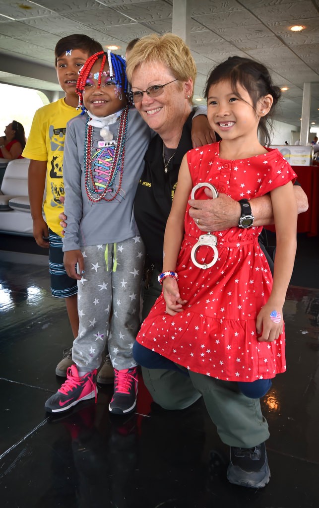 Orange County Sheriff Dep. Peters poses with kids during a 4th of July Newport Harbor Cruise for Make-a-Wish kids hosted by the OCSD. Photo by Steven Georges/Behind the Badge OC