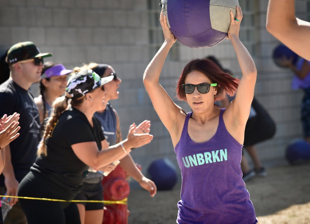 Sandra Arauza caries a medicine ball as people cheer during timed competition for the OCSD Women’s Fitness Challenge. Photo by Steven Georges/Behind the Badge OC