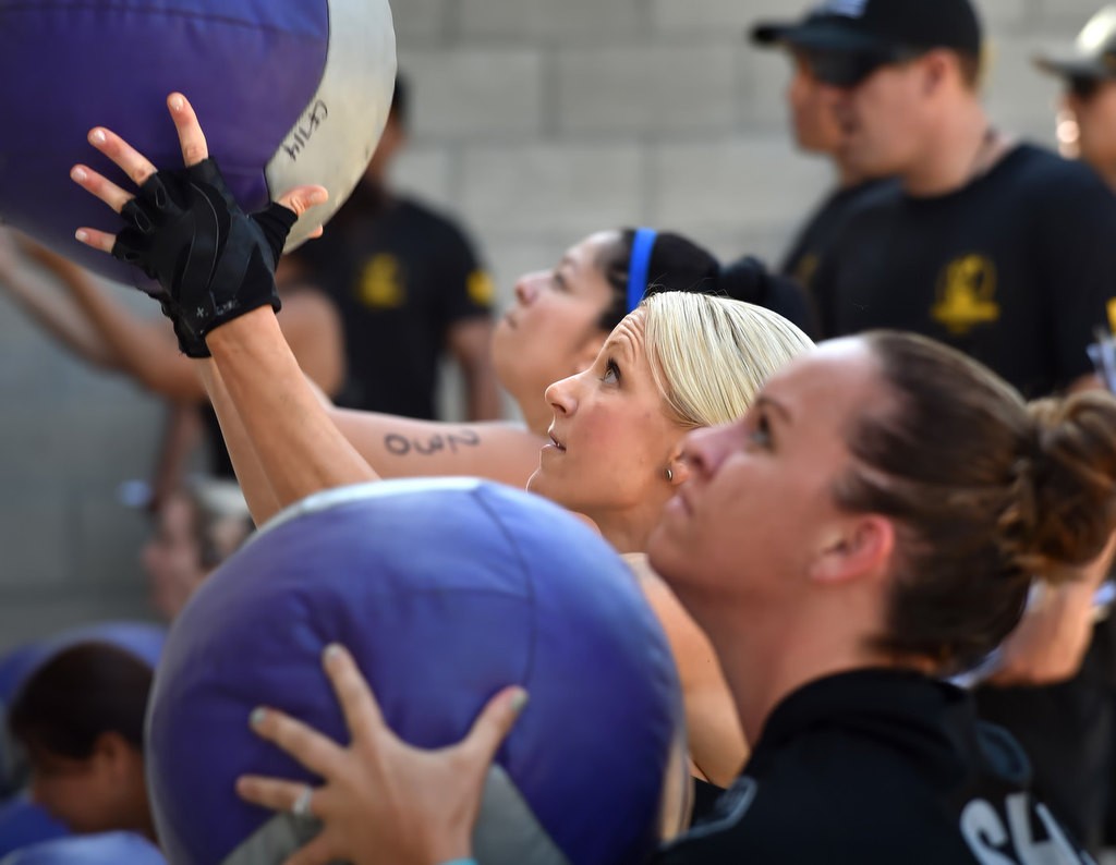 Michelle Perez, left, Dana Chaney and Jennifer Martinez, right, use medicine balls during timed competition for the OCSD Women’s Fitness Challenge. Photo by Steven Georges/Behind the Badge OC