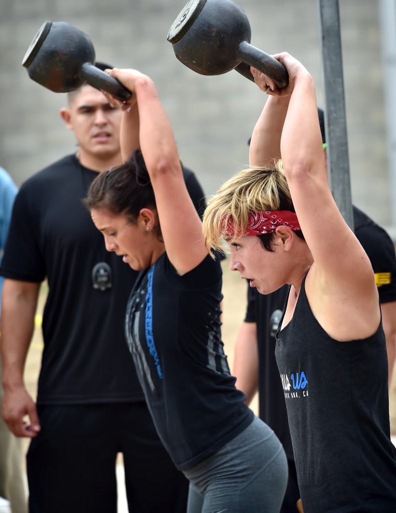 Zuleyma Sarmiento, left, and Kim Graeber swing 26 lbs weights above their heads during timed competition for the OCSD Women’s Fitness Challenge. Sarmiento went on to take 2nd place for Division I and Graeber took 3rd. Photo by Steven Georges/Behind the Badge OC