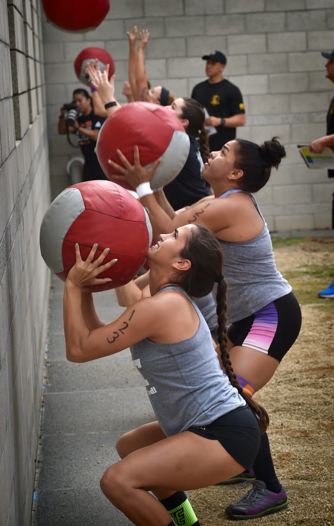 Rochelle Rivera, bottom, and Lorena Preciado behind her starts the timed competition by bouncing a medicine ball off a wall during the OCSD Women’s Fitness Challenge. Photo by Steven Georges/Behind the Badge OC
