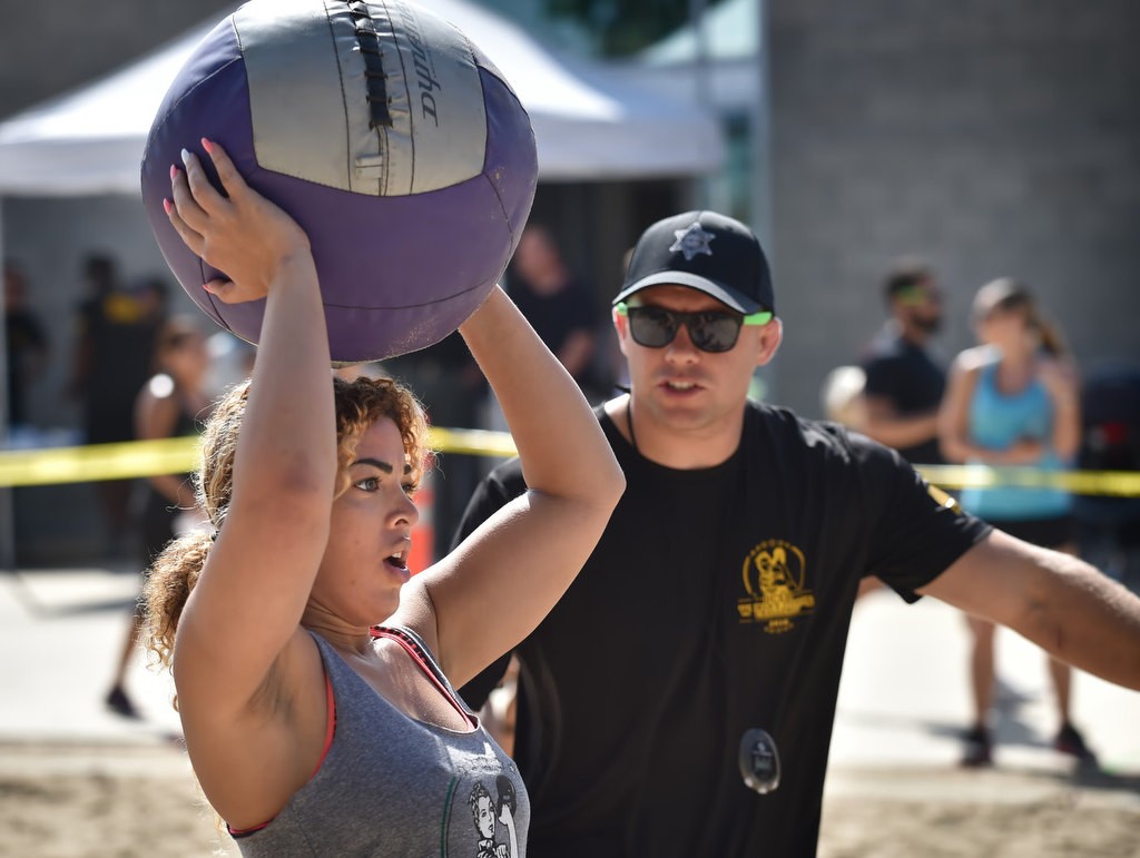 Jonnelle Cato caries a medicine ball to the next stage of a timed competition for the OCSD Women’s Fitness Challenge. Photo by Steven Georges/Behind the Badge OC