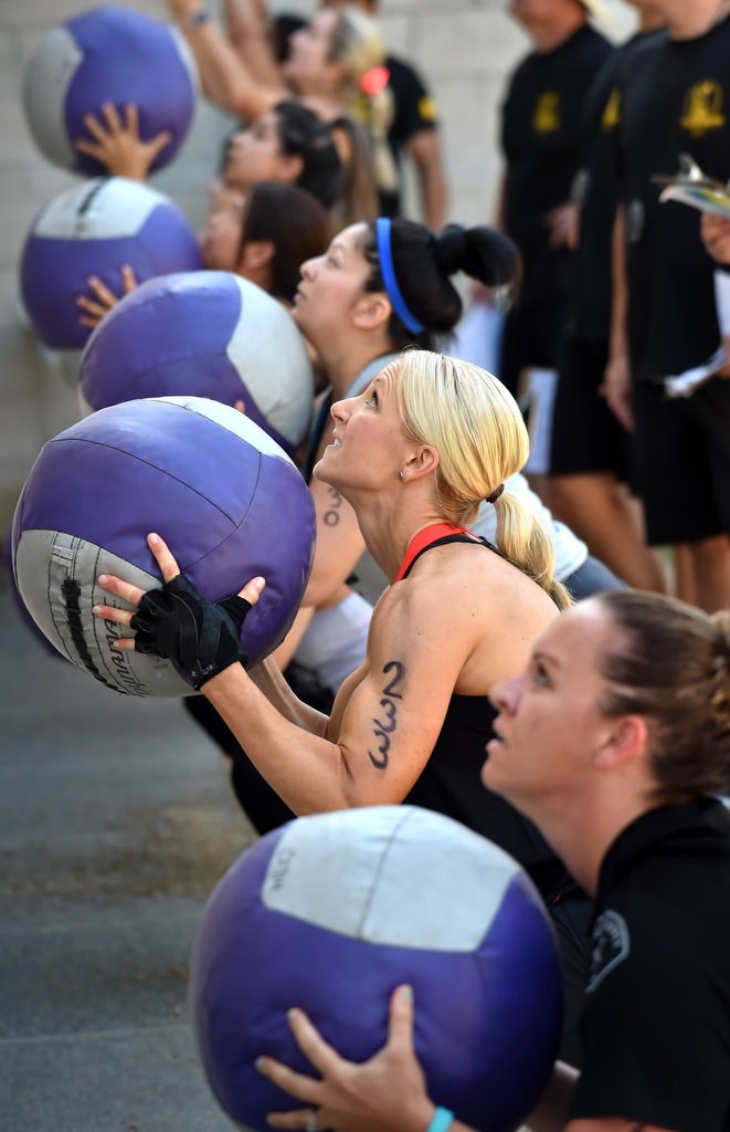 Michelle Perez, left, Dana Chaney and Jennifer Martinez, bottom right, use medicine balls during timed competition for the OCSD Women’s Fitness Challenge. Photo by Steven Georges/Behind the Badge OC