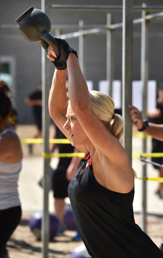 Dana Chaney swings a 26 lbs weight above her head during timed competition for the OCSD Women’s Fitness Challenge. Photo by Steven Georges/Behind the Badge OC