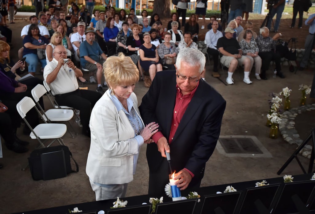 Pat Almazan, daughter of Frank Teplansky who was killed in the 1976 CSUF shootings, left, and Paul Paulsen, who’s sister Debbie Paulsen was also killed, lights a candle in remembrance of them and the five other victims who were killed that day. The ceremony at CSUF’s Memorial Grove marked the 40th anniversary of the shootings. Photo by Steven Georges/Behind the Badge OC