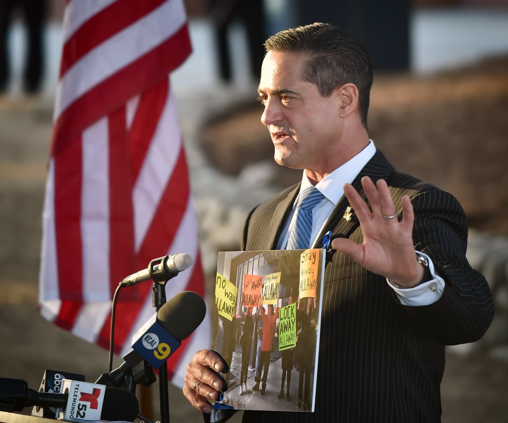 Supervisor Todd Spitzer holds up a photo of protesters as he talked about his efforts to keep the shooter of Cal State Fullerton massacre from being released from jail, during a remembrance memorial. Photo by Steven Georges/Behind the Badge OC