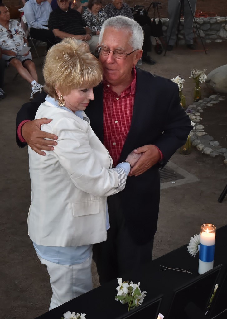 Pat Almazan, daughter of Frank Teplansky who was killed in the 1976 CSUF shootings, left, and Paul Paulsen, who’s sister Debbie Paulsen was also killed, gives each other a hug after lighting a candle in their honor. Photo by Steven Georges/Behind the Badge OC