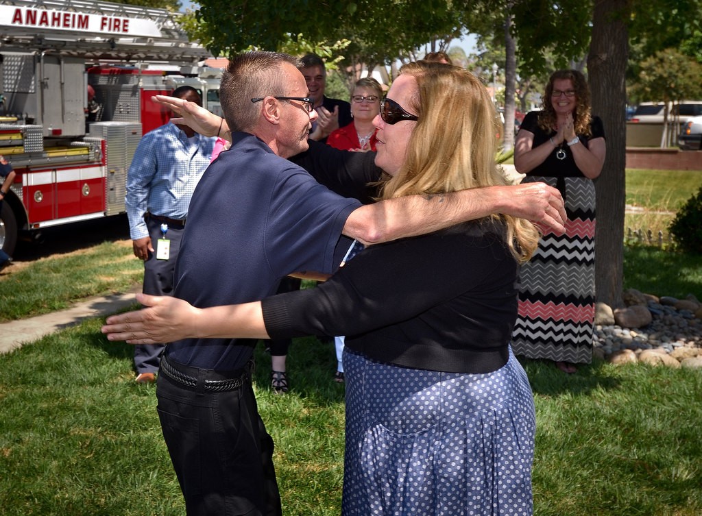 David Tompkins gets a hug from Amber Cooper as they meet for the first time in front of CooperÕs home in Anaheim. Tompkins was the ADT dispatcher that made the call to Anaheim Fire & Rescue that saved that saved Coopers dog, Fiona, from a house fire. Photo by Steven Georges/Behind the Badge OC