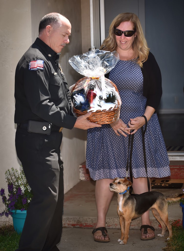 Anaheim Fire & Rescue Deputy Chief Rusty Coffelt presents Amber Cooper of Anaheim and her dog Fiona a gift basket that includes dog treats. Photo by Steven Georges/Behind the Badge OC
