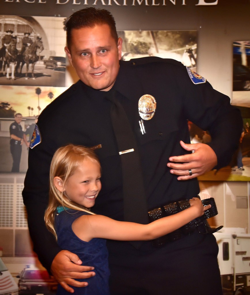 Gary “Dustin” Staal, formerly Laguna Beach PD and Huntington Park PD, gets a hug from his daughter after receiving his new badge as a Garden Grove PD officer. Photo by Steven Georges/Behind the Badge OC