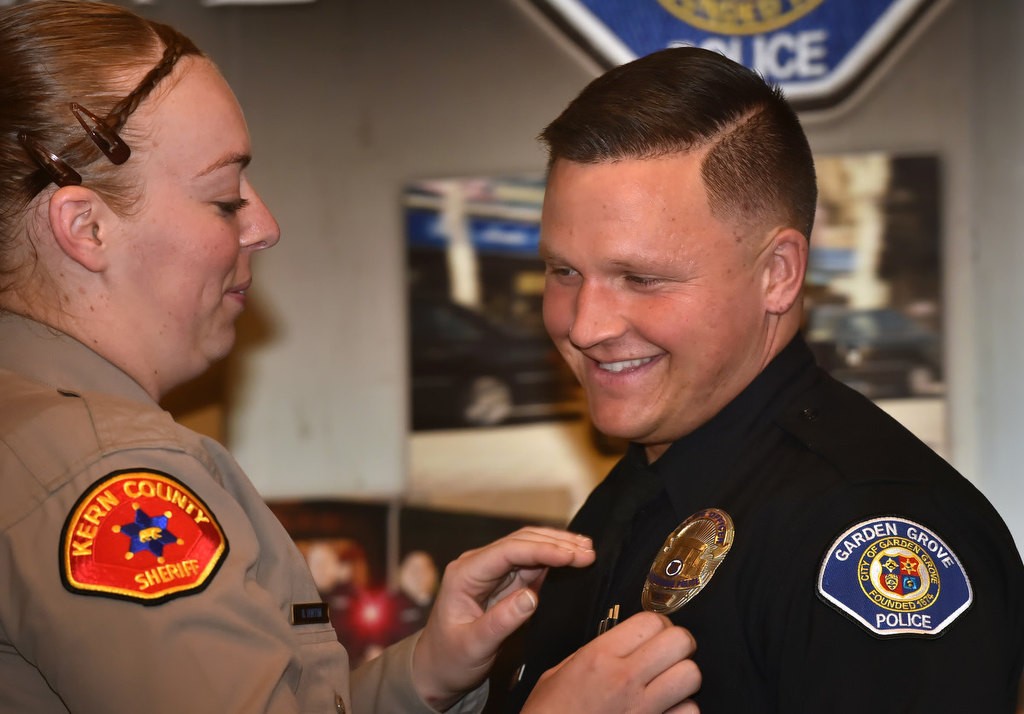 Hunter King, recently a Kern County Deputy Sheriff, receives his new badge as a Garden Grove PD officer during a ceremony at the community center. Photo by Steven Georges/Behind the Badge OC