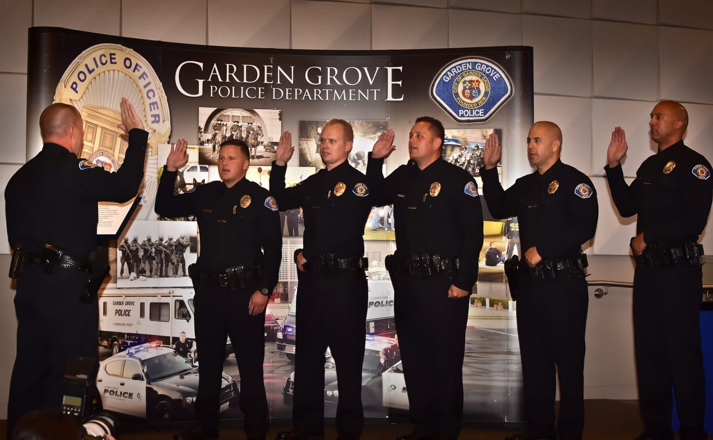 Garden Grove Police Chief Todd Elgin, left, swears in five new five new officers coming from other police agencies during a ceremony at the Garden Grove Community Meeting Center. Officers from left are Hunter King,Timothy Ashbaugh, Gary “Dustin” Staal, Arion “A.J.” Knight and Jerome Cheatham. Photo by Steven Georges/Behind the Badge OC