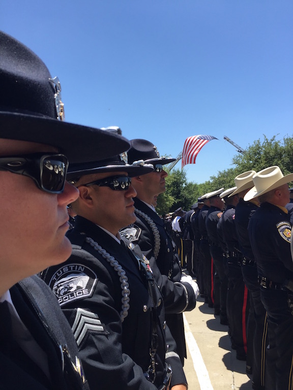 Tustin PD Sgt. Sarah Fetterling, Sgt. Manny Arzate and Det. Tommy Lomeli stand at attention during a memorial service to honor the fallen officers in Dallas. Photo courtesy Tustin PD. 