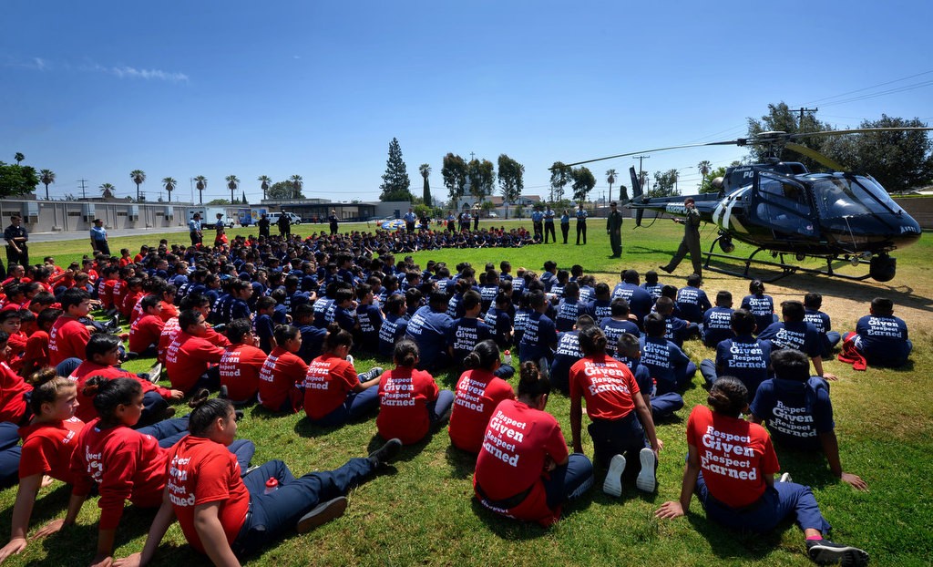 Anaheim PD pilots Josh Blackburn and Dietrich Messier, right, talks to kids attending the Anaheim PD Cops 4 Kids Jr. Cadet Academy after landing the “Angel” APD helicopter at Betsy Ross Elementary. Photo by Steven Georges/Behind the Badge OC