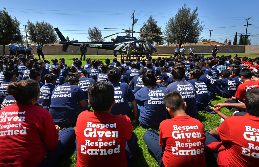 Respect Given is Respect Earned reads the shirts of the kids at the Anaheim PD Cops 4 Kids Jr. Cadet Academy as they gather around an APD “Angel” helicopter that landed at Betsy Ross Elementary. Photo by Steven Georges/Behind the Badge OC
