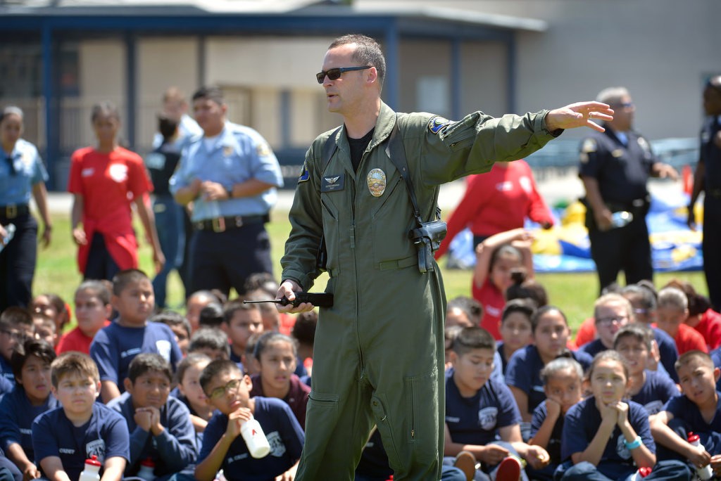 Anaheim PD Pilot Dietrich Messier talks to kids attending the Anaheim PD Cops 4 Kids Jr. Cadet Academy after landing the “Angel” APD helicopter at Betsy Ross Elementary. Photo by Steven Georges/Behind the Badge OC