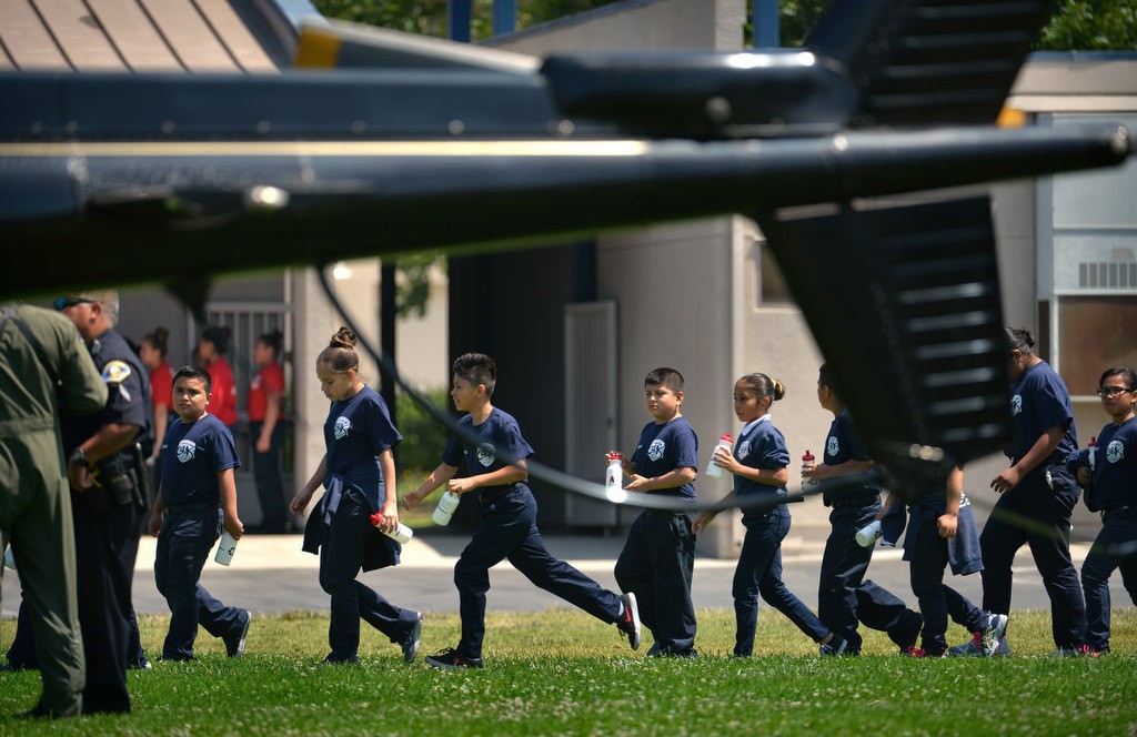 Kids from the Anaheim PD Cops 4 Kids Jr. Cadet Academy walk up to hear the pilots from the APD “Angel” helicopter that just landed at Betsy Ross Elementary. Photo by Steven Georges/Behind the Badge OC