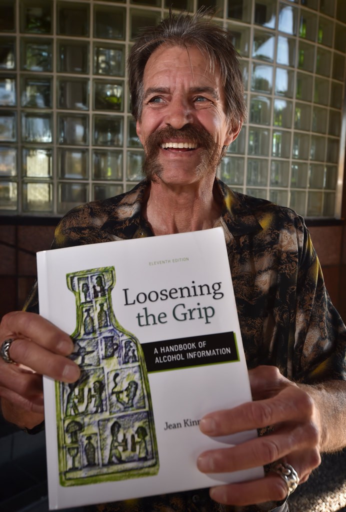 Former meth addict Bill Easton with the book Loosening the Grip by Jean Kinney as he attends InterCoast College. Photo by Steven Georges/Behind the Badge OC