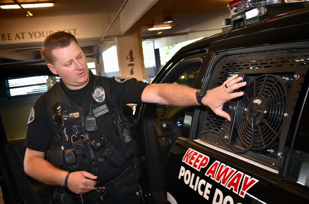 Officer Travis Hartman of Westminster PD shows one of the fans embedded in the back window used to keep Pako, his K9 partner, cool on hot sunny days. The window also automatically opens if the air conditioner fails to keep the temperature bellow a set amount. Photo by Steven Georges/Behind the Badge OC