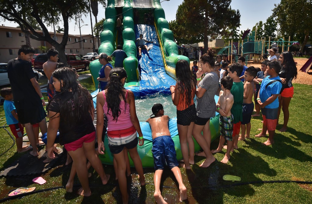 Kids line up for the giant water slide at Montwood Park during the Cool Cops community outreach gathering. Photo by Steven Georges/Behind the Badge OC