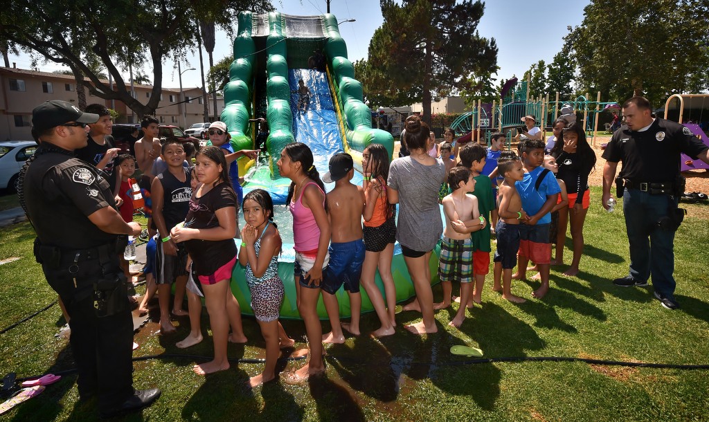 La Habra officers get the kids to chant to get Det. Daniels to go down the water slide. Photo by Steven Georges/Behind the Badge OC