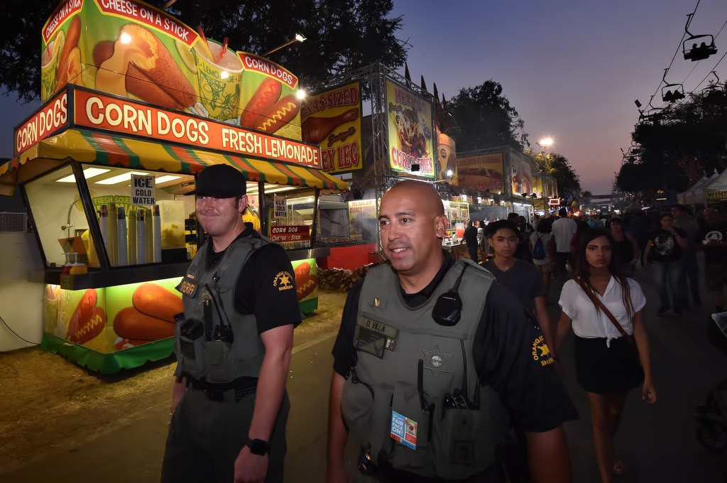 OC Sheriff deputies Chris Emerson, left, and Dan Villa walk patrol as the sun sets at the Orange County Fair. Photo by Steven Georges/Behind the Badge OC