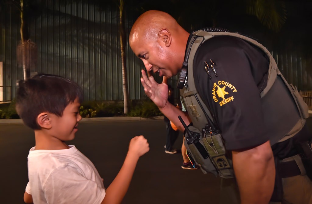 OC Sheriff Dept. Dan Villa gets a fist bump from 8-year-old Blake Ly of Garden Grove as he says goodby to the OC Fair’s kids lost and found after his mother came to pick him up. Photo by Steven Georges/Behind the Badge OC