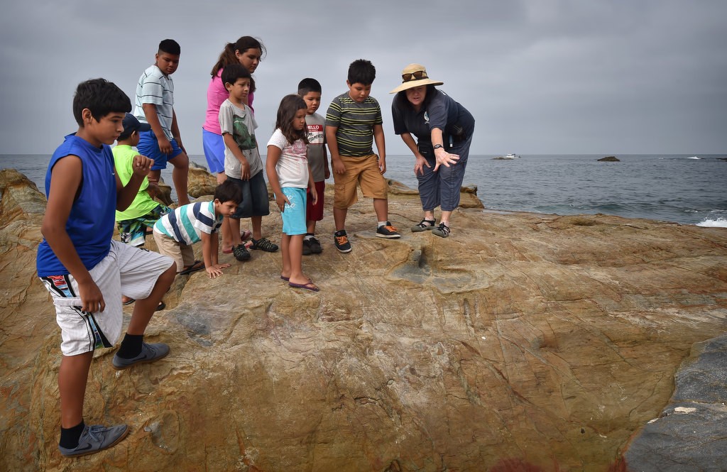 Laguna Beach’s Marine Safety Tide Pool Educator Amee Penso, right, talks about the marine life at the Laguna Beach tide pools, part of an Orange County Family Justice Center Foundation program. Photo by Steven Georges/Behind the Badge OC
