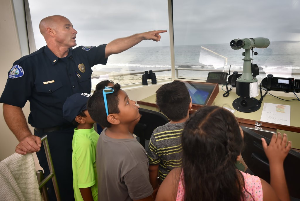 Laguna Beach Lifeguard Lt. Kai Bond shows the Orange County Family Justice Center Foundation kids the view from the second floor of the Laguna Beach lifeguard tower during a field trip. Photo by Steven Georges/Behind the Badge OC