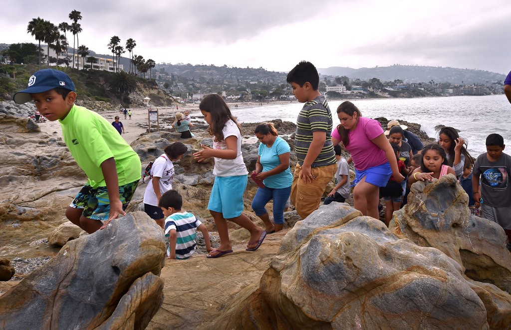 Kids climb around the tide pools at Laguna Beach during a field trip organized by the Orange County Family Justice Center Foundation. Photo by Steven Georges/Behind the Badge OC