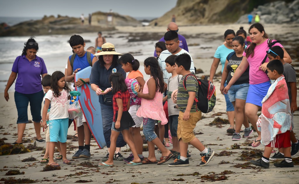 Laguna Beach’s Marine Safety Tide Pool Educator Amee Penso shows the Orange County Family Justice Center Foundation kids the marine life at the Laguna Beach tide pools and beach. Photo by Steven Georges/Behind the Badge OC