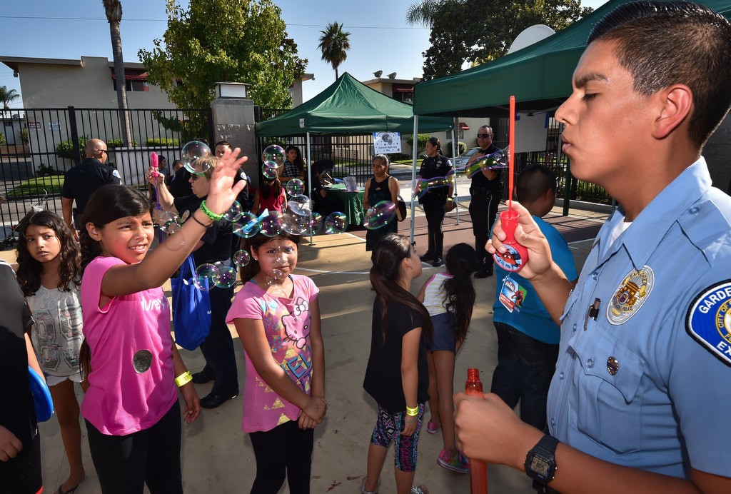 Jason Brito, a Garden Grove police explorer for 3 years, blows bubbles for the kids of Buena Clinton Youth & Family Center in Garden Grove during National Night Out. Photo by Steven Georges/Behind the Badge OC