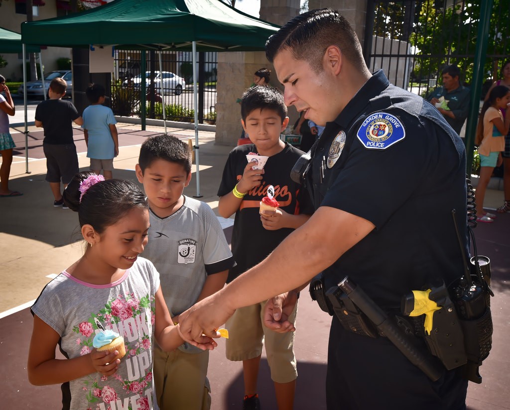 Garden Grove PD Officer Joshua Escobedo talks to the kids at Buena Clinton Youth & Family Center in Garden Grove during National Night Out. Photo by Steven Georges/Behind the Badge OC