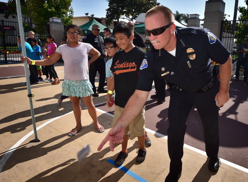 Garden Grove Police Chief Todd Elgin challenges the kids of Buena Clinton Youth & Family Center to a game of bean bag toss, part of National Night Out. Photo by Steven Georges/Behind the Badge OC