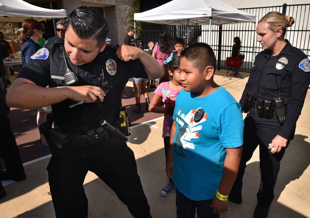 Garden Grove PD Officer Joshua Escobedo gives tips on how to knock down the pins as kids from Buena Clinton Youth & Family Center interact with officers during National Night Out. Photo by Steven Georges/Behind the Badge OC