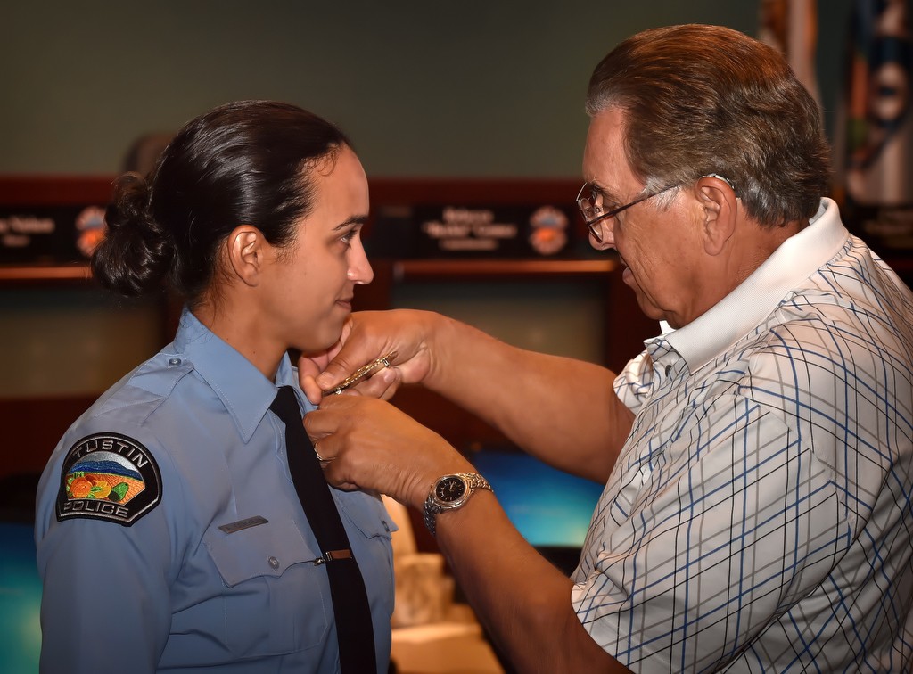 Tustin Police Services Officer Alysia Cornell has her badge pinned to her by her father, Ralph, during a promotions and swearing in ceremony. Photo by Steven Georges/Behind the Badge OC