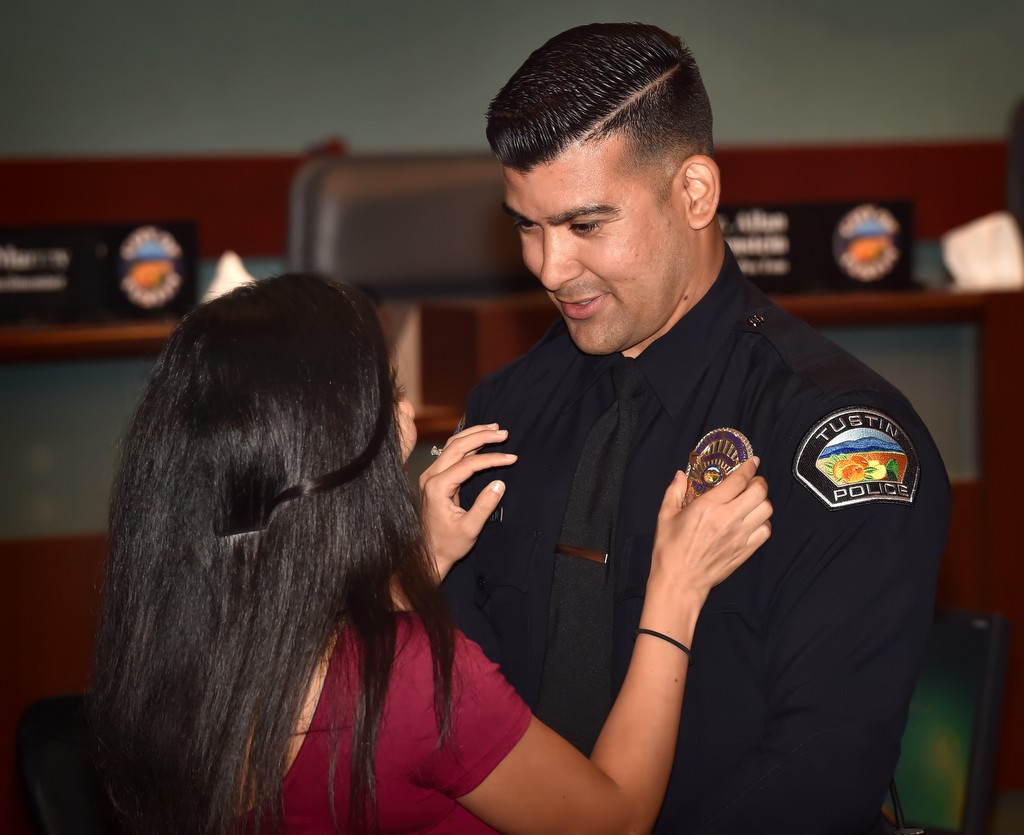 Tustin PD Officer Charles Carter has his new badge pinned to him by his wife, Sandeep, during a promotions and swearing in ceremony. Carter’s brother, Michael Carter, also serves as an officer with the Tustin PD. Photo by Steven Georges/Behind the Badge OC