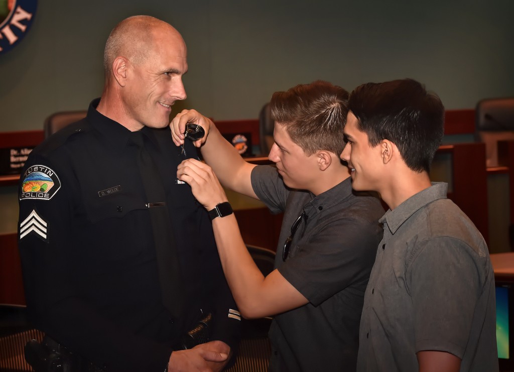 Tustin PD Sgt. David Welde gets his new badge pinned to him by his sons, Chris and Brian, during a promotions and swearing in ceremony. Photo by Steven Georges/Behind the Badge OC