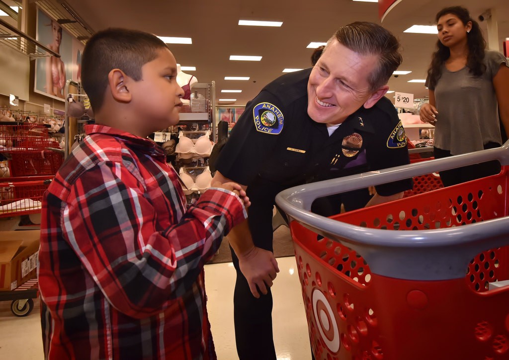 Anaheim PD Deputy Chief Dan Cahill helps 7-year-old Aaron shop for the clothes he needs for the start of the school year. Photo by Steven Georges/Behind the Badge OC