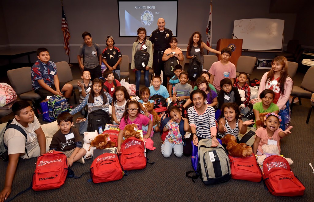Anaheim PD Lt. James Kazakos, back center, with OCFJC Foundation kids after they received their new back to school backpacks. Photo by Steven Georges/Behind the Badge OC