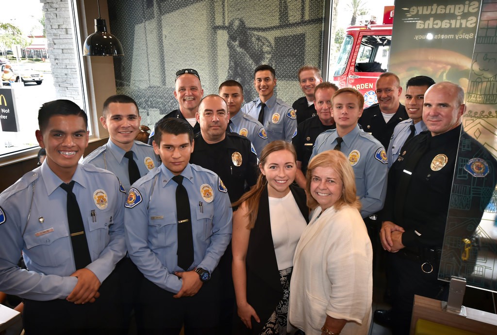 Sam Widdecombe, center left, and Patti Widdicombe of the family owned Valley View McDonald’s in Garden Grove, with Garden Grove PD command staff, that includes Chief Todd Elgin, and Garden Grove Explorers inside the rebuilt Valley View McDonald’s that includes a large photo of the Garden Grove Police Memorial inside the dinning room. Photo by Steven Georges/Behind the Badge OC