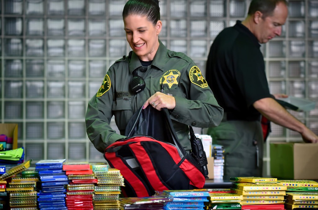Dep. Heather Drummond fills backpacks with school supplies for kids in need. Photo by Steven Georges/Behind the Badge OC