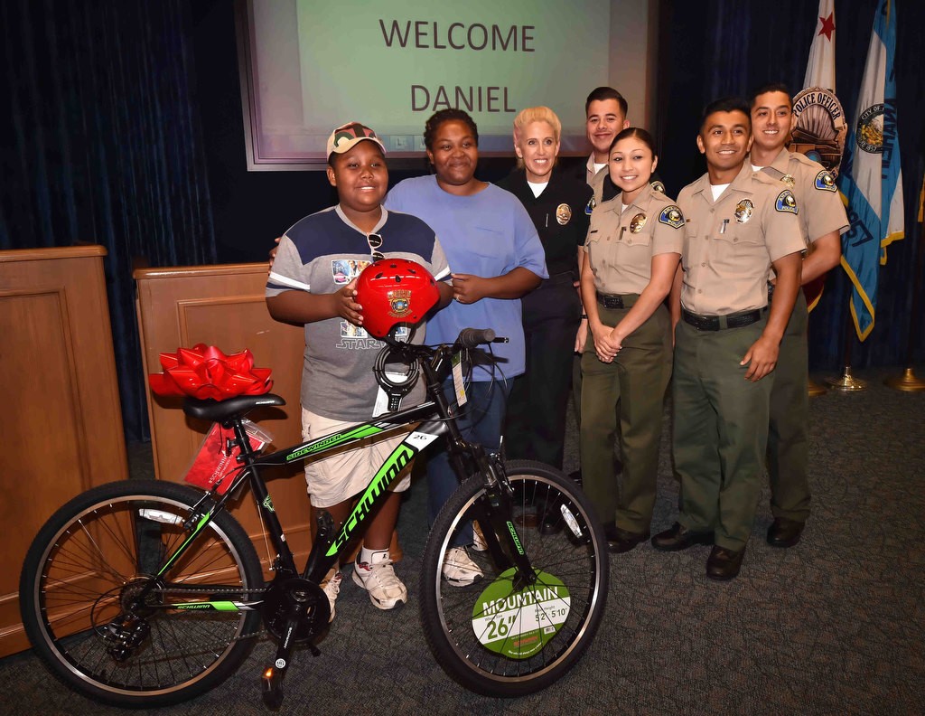 Daniel Cowboy and his mother Andrea Cowboy with his new bicycle gathers with Officer Sarah Shirvany and Anaheim PD explorers. Photo by Steven Georges/Behind the Badge OC