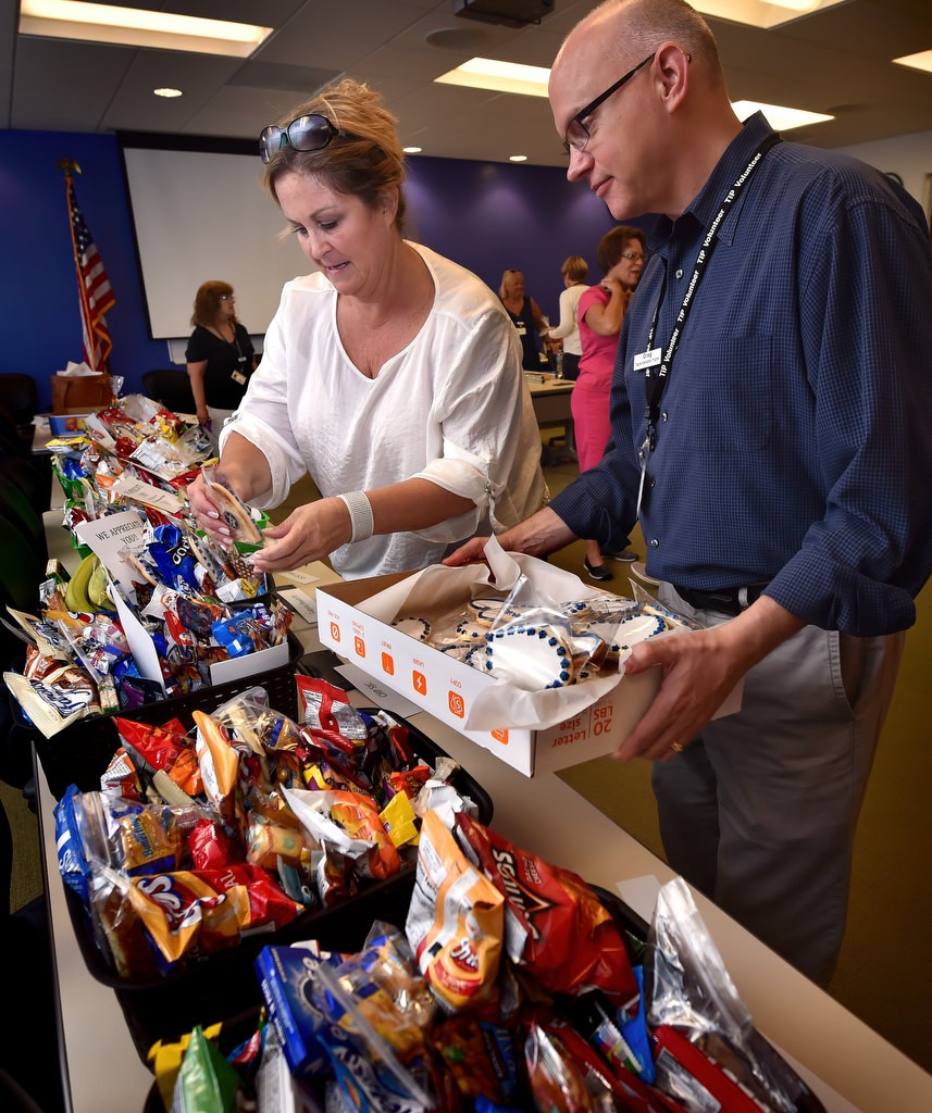 TIP Volunteers Tina Swift, left, and Greg Cline help assemble appreciation gift baskets for police agencies. Photo by Steven Georges/Behind the Badge OC