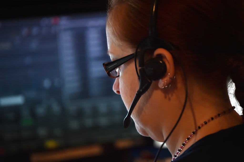 Garden Grove PD Public Safety Dispatcher Susan Seymour at her station. Unlike many other dispatch centers, each dispatcher is responsible for both taking calls as well as calling out to patrol cars. Photo by Steven Georges/Behind the Badge OC