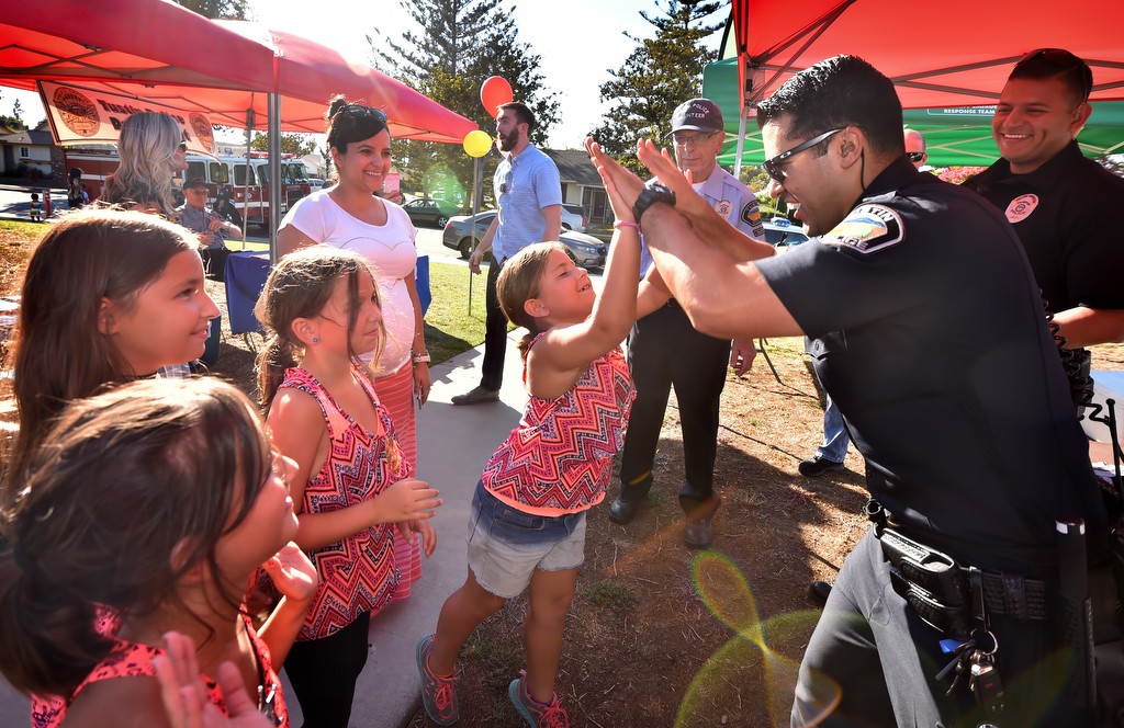 Tustin PD Officer Michael Carter gives high-fives to girls from Compass Bible Church in Tustin after they gave the officers cookies in appreciation for helping to make Frontier Park a safe place for kids again. Photo by Steven Georges/Behind the Badge OC