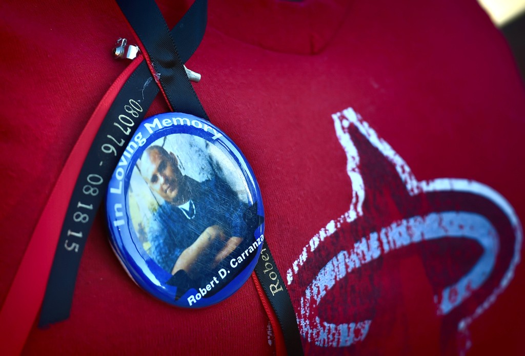 Amanda Cuellar wears a memorial button of her brother, Robert Carranza, who was killed in Frontier Park a year ago on Aug 18, 2015. Photo by Steven Georges/Behind the Badge OC