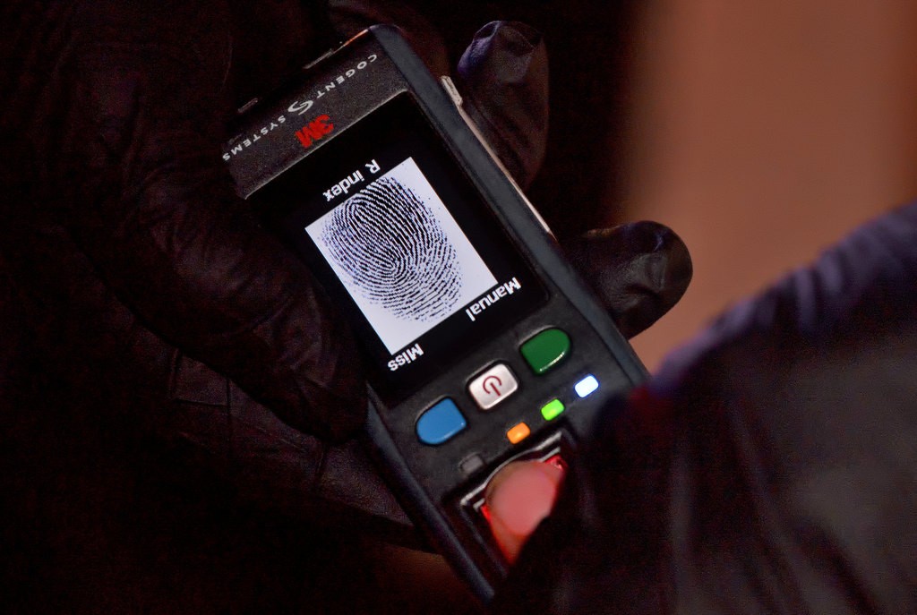 A portable digital fingerprint scanner is used on the location of a call to double check the ID of someone being questioned. Photo by Steven Georges/Behind the Badge OC